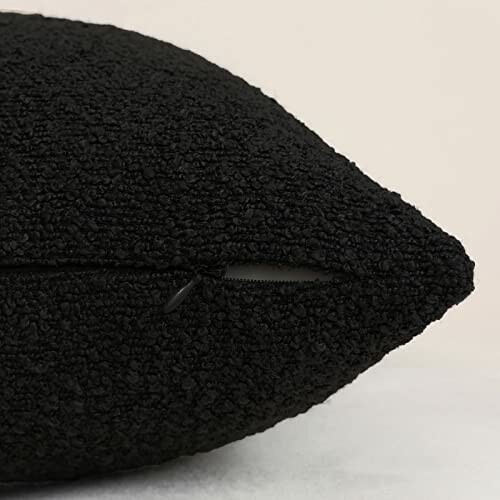 Close-up of a black textured pillow with a zipper.