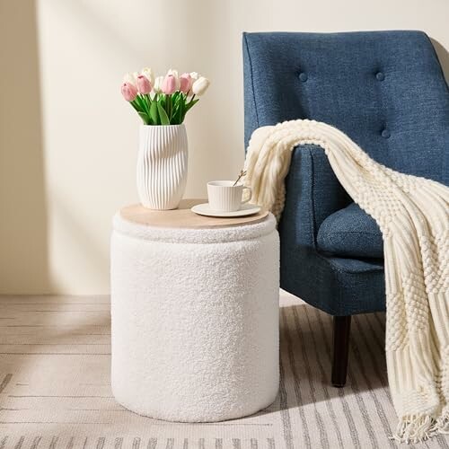 Cozy living room with chair, vase of tulips, and side table with cup.