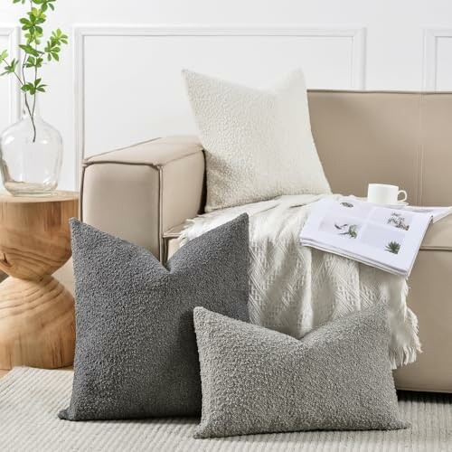 Living room with beige sofa, textured pillows, and a small table with a plant.