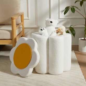 White plush storage bin with stuffed animals in a cozy room.