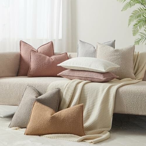 Assorted textured pillows on a sofa with a throw blanket.