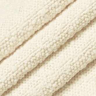 Close-up of a cream textured blanket with a soft, woven pattern.