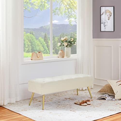 Elegant living room with a cream bench, large window, and decorative items.