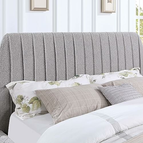 Gray upholstered bed headboard with pillows in a bright room.