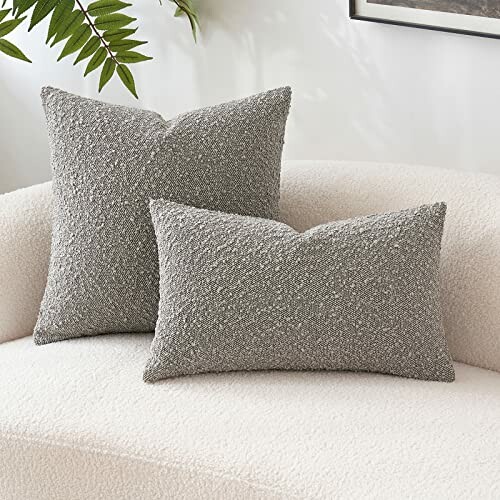 Two grey textured throw pillows on a white couch.