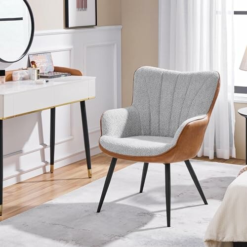 Modern accent chair in a bedroom with a vanity desk and a TV stand.