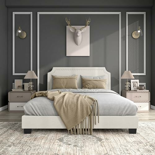 Modern bedroom with gray walls, upholstered bed, and decorative deer head.