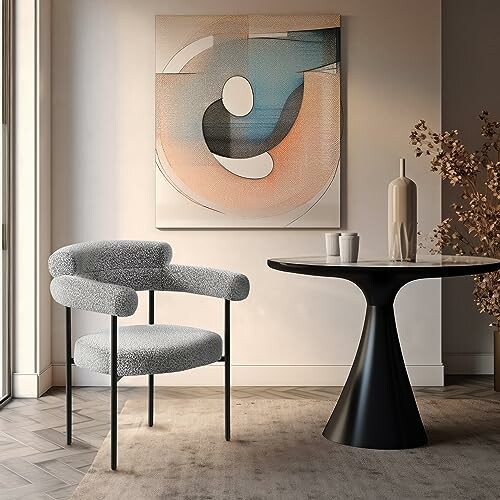 Modern chair and abstract art beside a round table in a stylish room