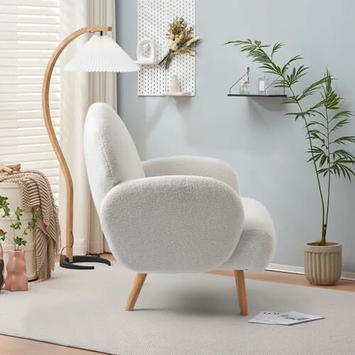 Cozy modern living room with a white armchair, floor lamp, and indoor plant.