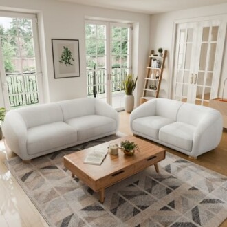 Bright living room with two white sofas, wooden coffee table, and large windows.