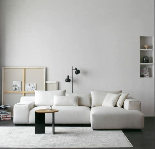 Minimalist living room with white sofa and modern decor.