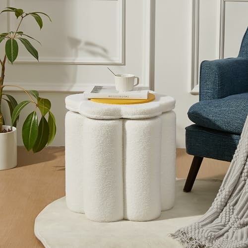 White fluffy stool used as a coffee table with book and cup.