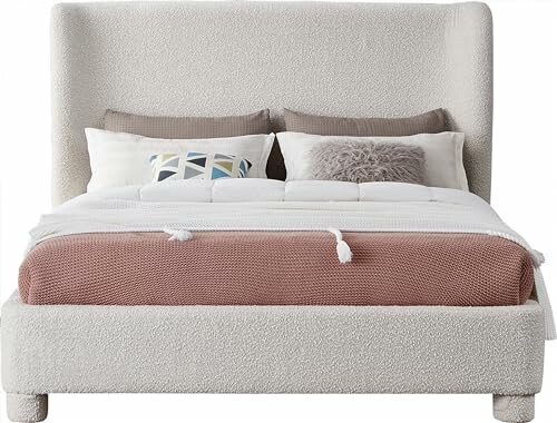 Modern upholstered bed with pillows and blanket