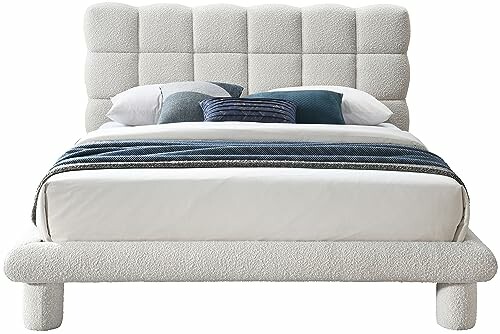 Modern upholstered bed with cushioned headboard and bedding.