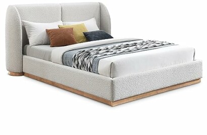 Modern upholstered bed with pillows and decorative blanket