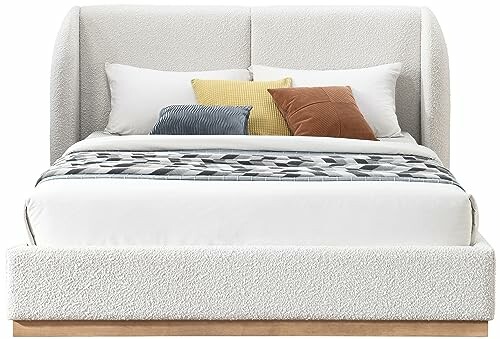 Modern upholstered bed with pillows and blanket