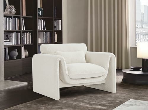 Modern white armchair in a stylish living room with bookshelves.