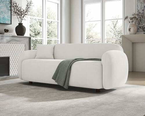 Modern white sofa in a bright living room with large windows