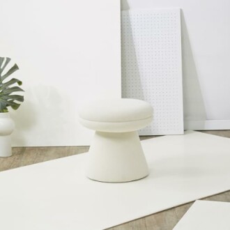 Minimalistic white stool in a contemporary setting with white decor elements.