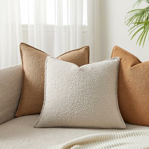 Four neutral-colored throw pillows on a sofa.