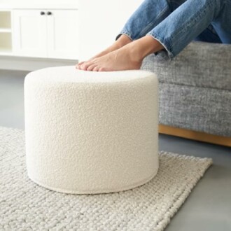 Person resting feet on a round white footstool