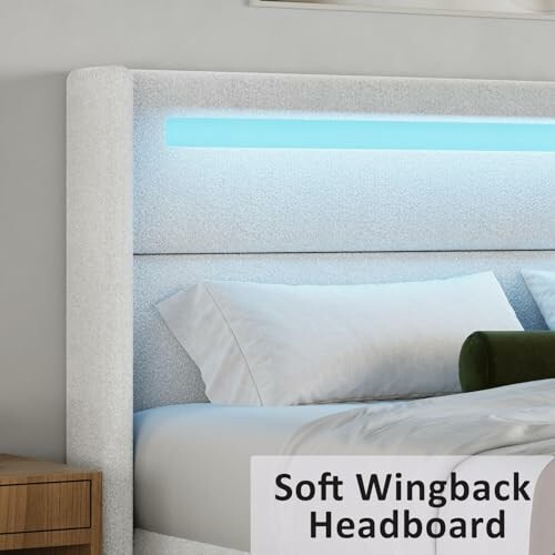 Soft wingback headboard with illuminated panel and pillows.