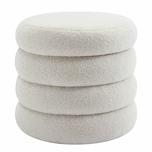 Four stacked circular cream cushions in a fluffy texture, showcasing the soft and cozy design of boucle furnishings.