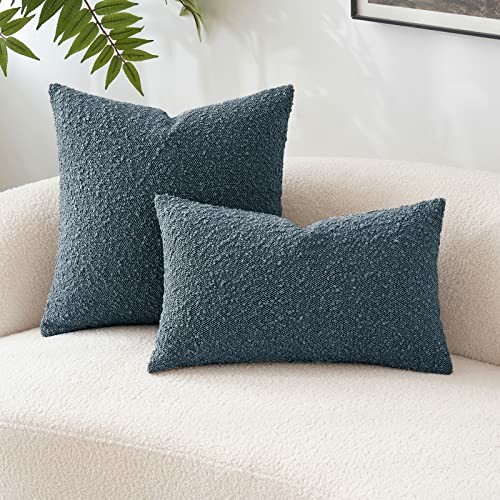 Two textured blue throw pillows on a cream sofa.