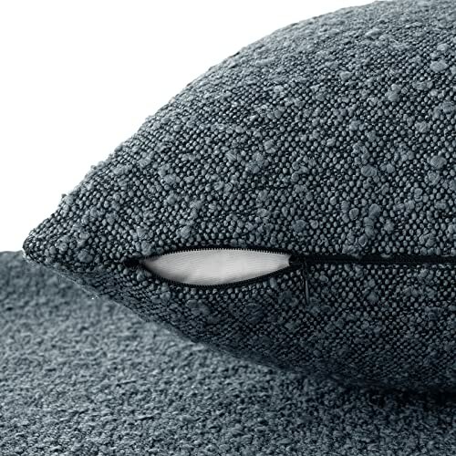 Close-up of a textured grey pillow with a zipper.