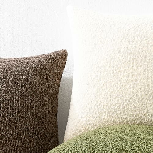 Close-up of three textured throw pillows in beige, cream, and green.