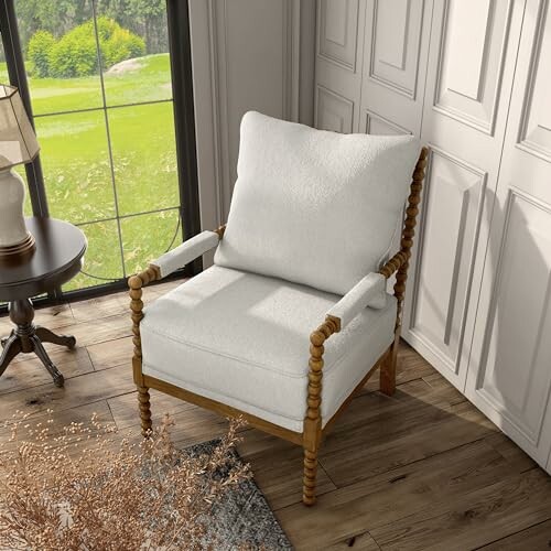 A White armchair by a window with wooden floor and side table, showcasing its elegant design and comfortable look.